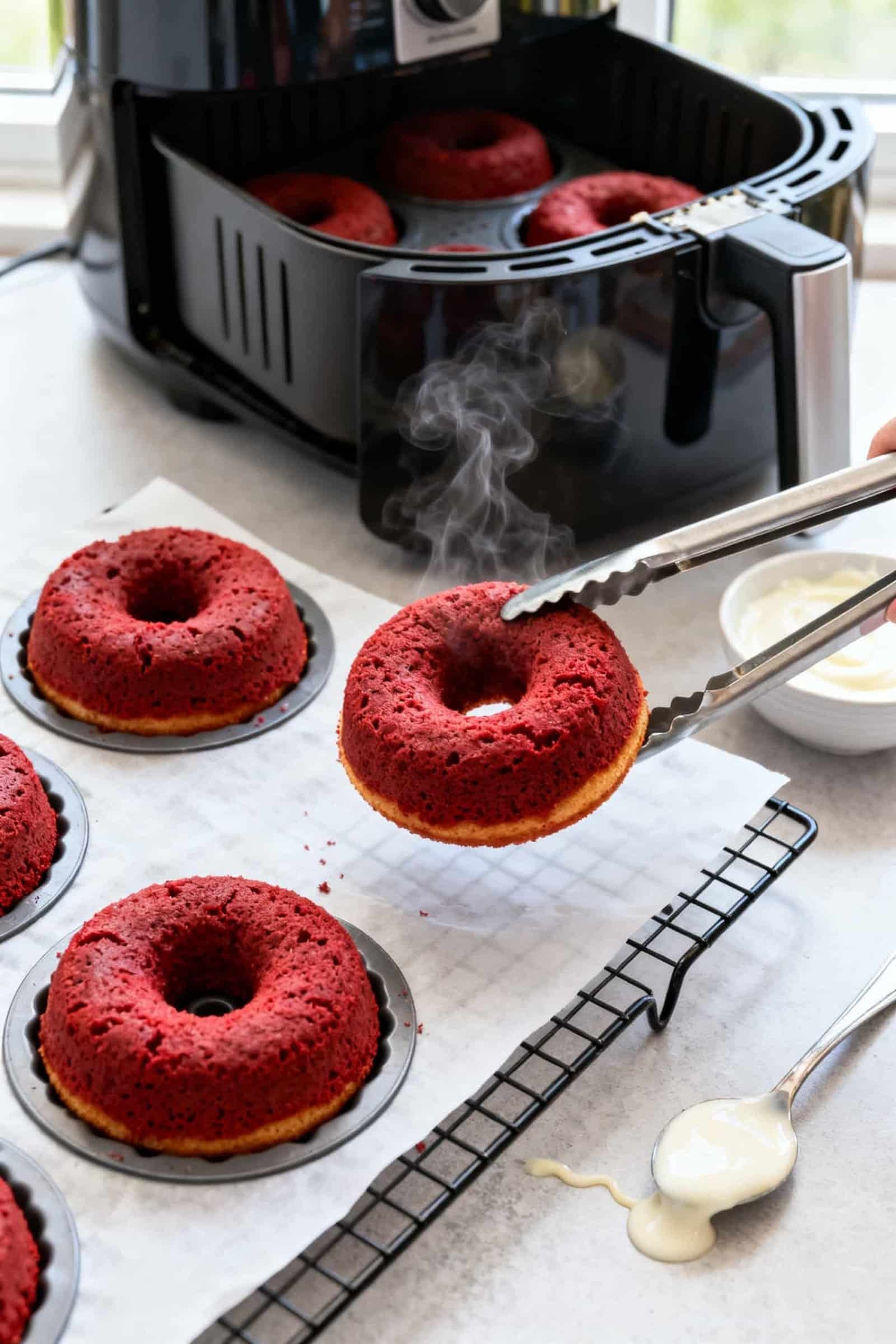 Close-up detail and process: Air fryer red velvet donuts just finished cooking in silicone donut mol