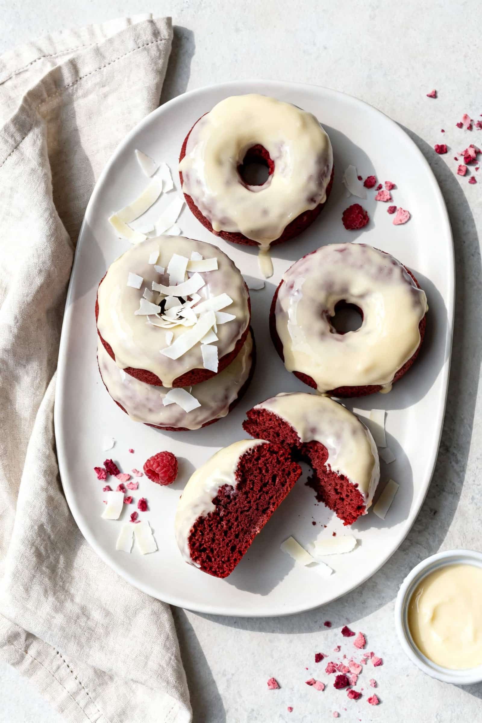 Final plated, tasty top view: Overhead shot of fully cooled red velvet donuts dipped in glossy cream